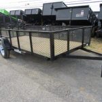 a trailer is parked on the side of the road next to a row of dump trailers