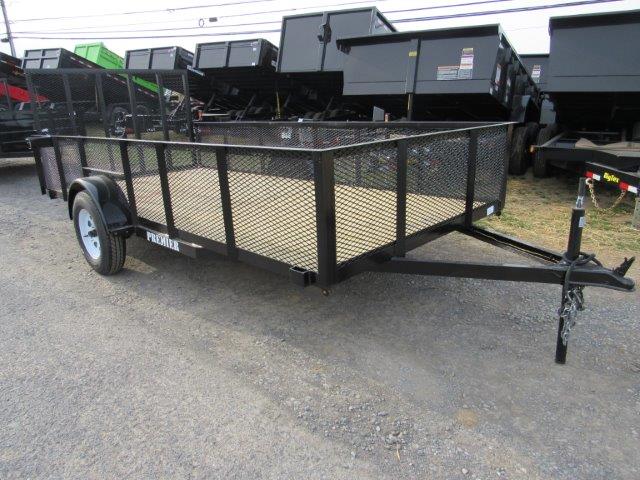 a trailer is parked on the side of the road next to a row of dump trailers