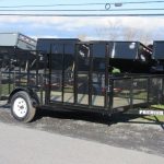 a black trailer is parked on the side of the road