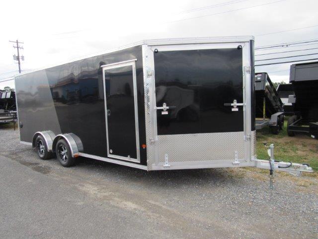 a black and silver trailer is parked on the side of the road .