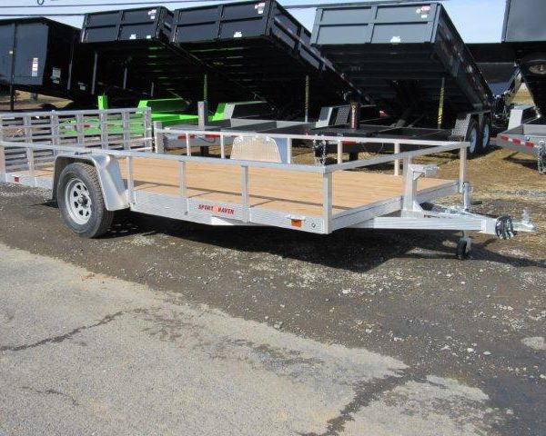 a silver trailer with a wooden deck is parked on the side of the road