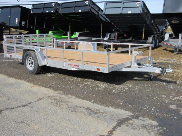 a silver trailer with a wooden deck is parked on the side of the road