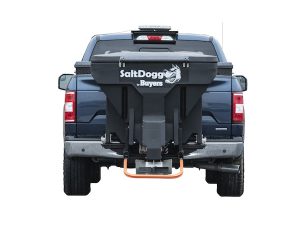 the back of a blue truck with a salt spreader attached to it .