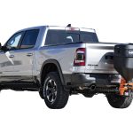 a silver ram truck with a salt spreader attached to the back of it