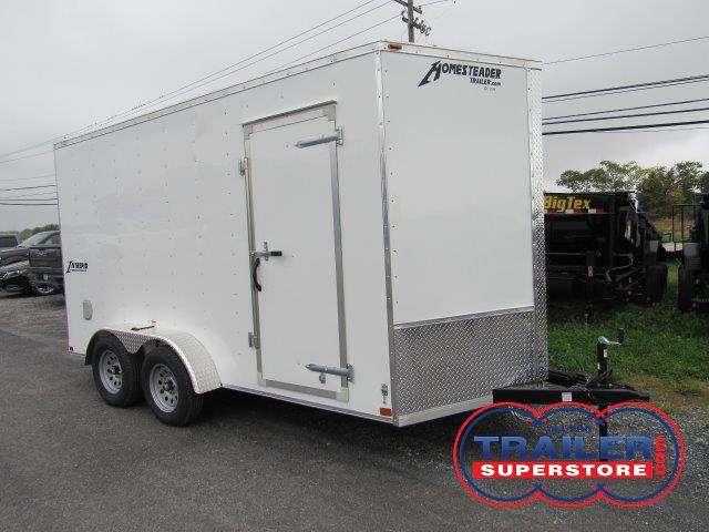 a white trailer is parked on the side of the road .