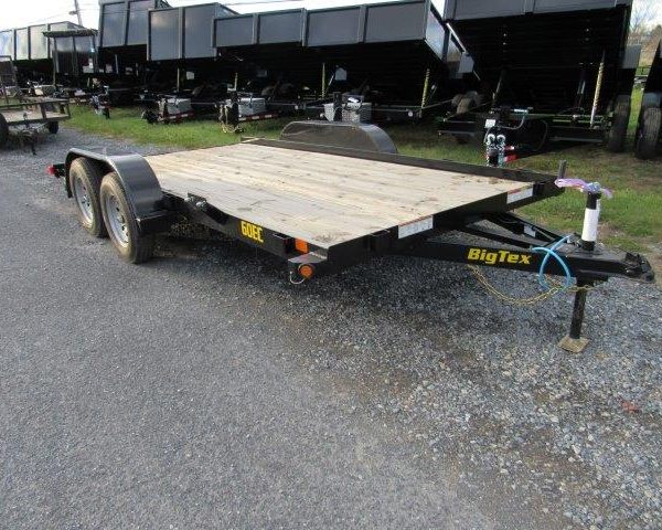 a trailer with a wooden deck is parked on the side of the road