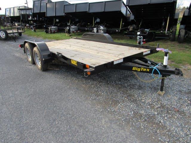 a trailer with a wooden deck is parked on the side of the road