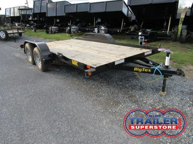 a trailer with a wooden deck is parked on the side of the road