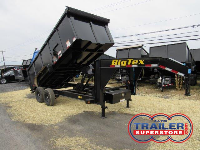 a big tex dump trailer is sitting on top of a dirt field .