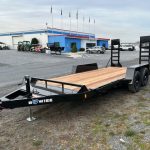 a bwise trailer is parked in a parking lot in front of a building .