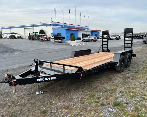 a bwise trailer is parked in a parking lot in front of a building .