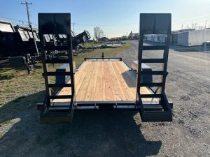 a trailer with a wooden deck is parked in a parking lot .
