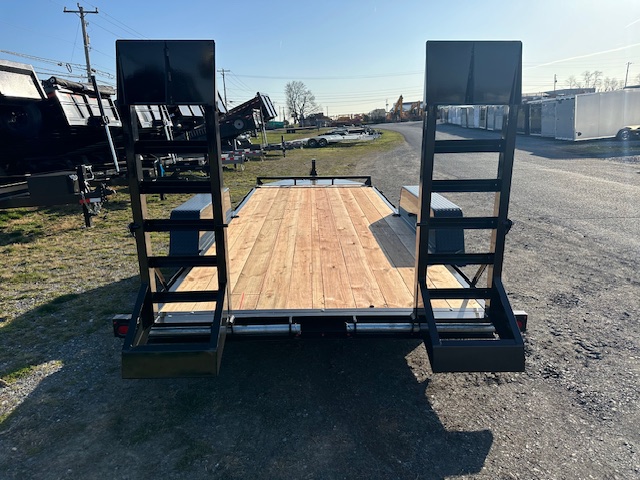 a trailer with a wooden deck is parked in a parking lot .