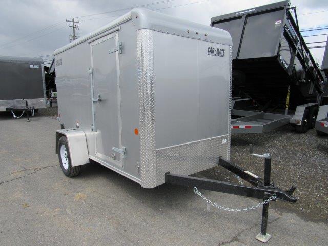 a silver trailer is parked in a parking lot next to a dump trailer
