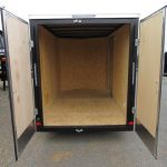 the inside of an empty trailer with its doors open .