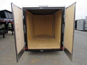 the inside of an empty trailer with its doors open .