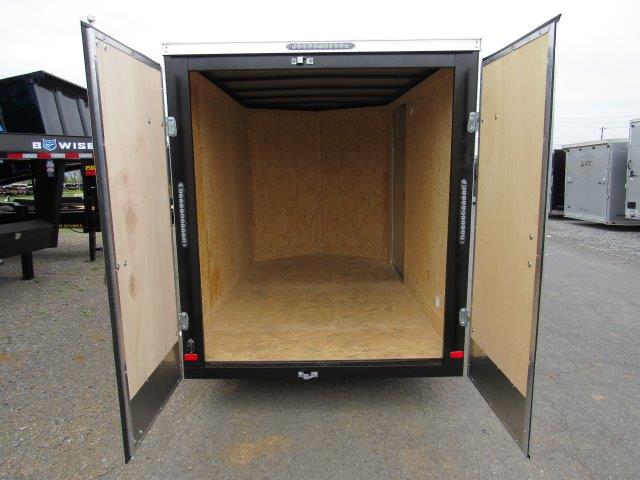 the inside of an empty trailer with its doors open .