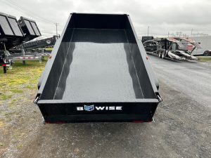 a dump trailer is parked on the side of the road .