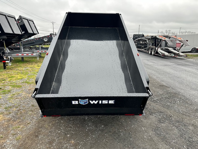 a dump trailer is parked on the side of the road .