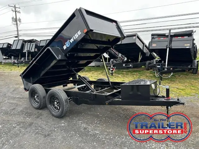 a bwise dump trailer is parked in a gravel lot