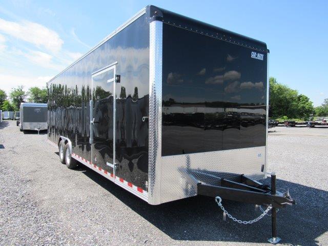 a black and silver trailer parked in a gravel lot