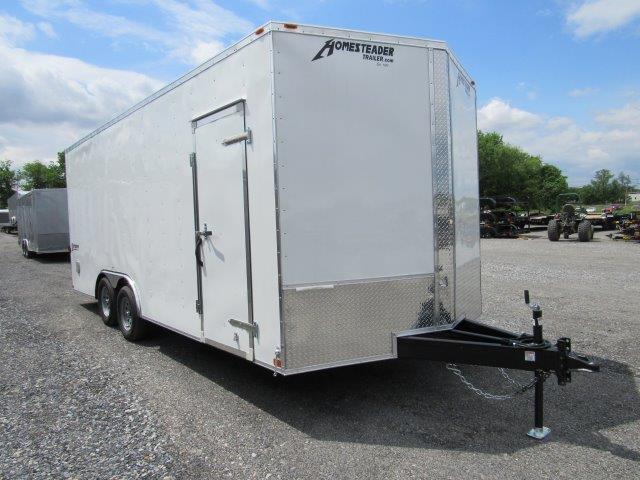 a white trailer parked in a gravel lot