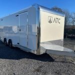 a white trailer parked in a gravel lot