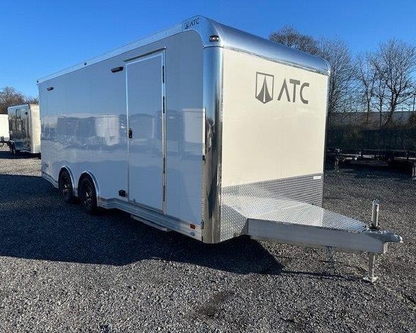 a white trailer parked in a gravel lot