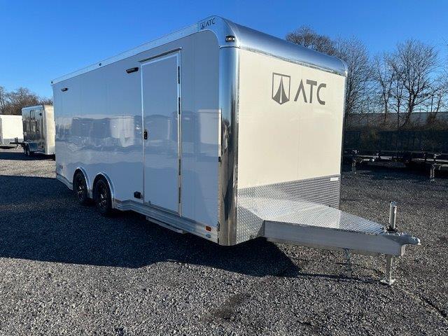 a white trailer parked in a gravel lot