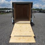a trailer with the door open and a wooden ramp .