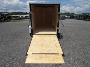 a trailer with the door open and a wooden ramp .