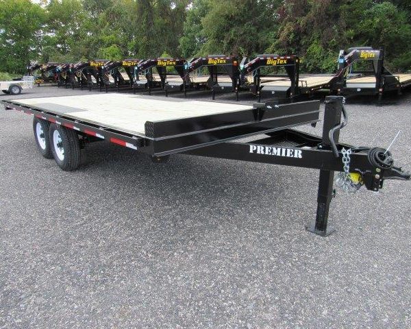 a row of trailers are parked in a gravel lot .