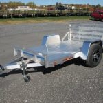 a Sport Haven aluminum utility trailer is parked in a gravel parking lot