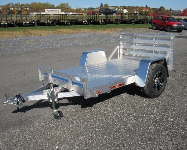 a Sport Haven aluminum utility trailer is parked in a gravel parking lot