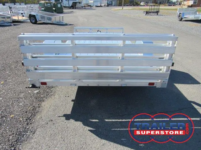 a small aluminum trailer is parked on the side of the road .