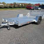 a silver trailer parked in a gravel lot