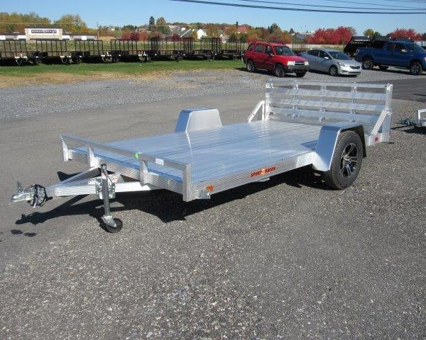 a silver trailer parked in a gravel lot