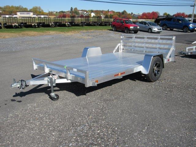 a silver trailer parked in a gravel lot