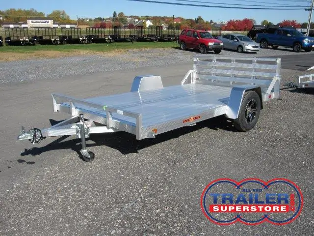 a silver trailer parked in a gravel lot
