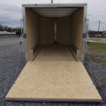 a trailer with the door open is sitting in a gravel lot .