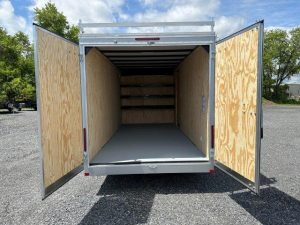 the inside of a trailer with the doors open is empty .