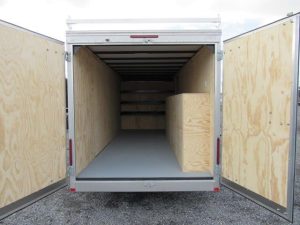 the inside of a car mate trailer with the doors open .