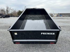 a Premier dump trailer parked in a gravel lot