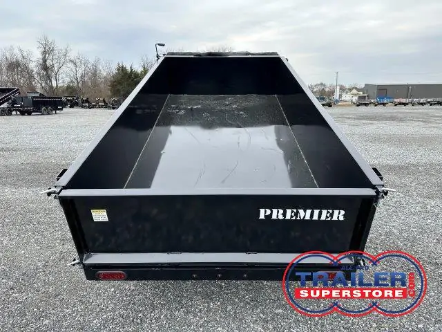 a Premier dump trailer parked in a gravel lot