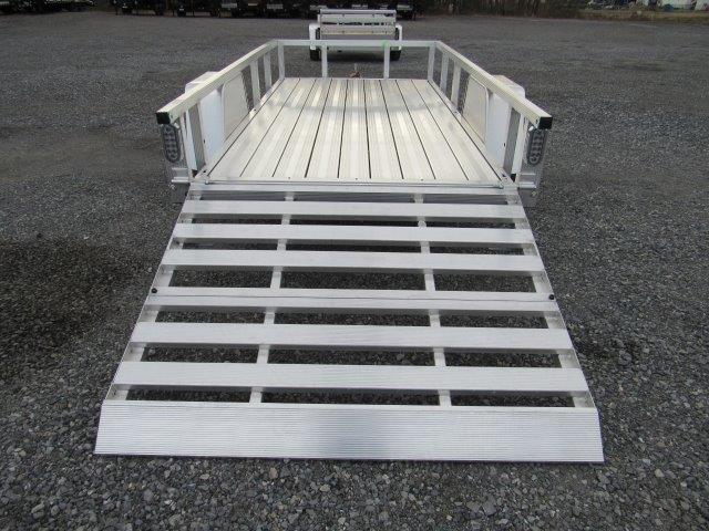a Sport Haven trailer with a ramp attached to it parked in a gravel lot