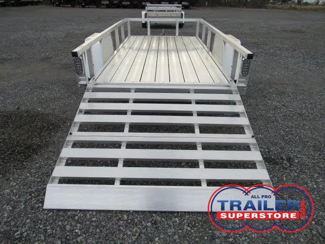 a Sport Haven trailer with a ramp attached to it parked in a gravel lot
