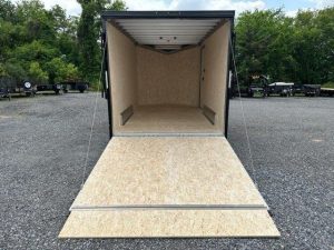 an ATC trailer with the door open parked in a gravel lot