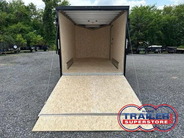 an ATC trailer with the door open parked in a gravel lot