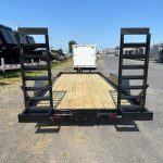 a trailer with a wooden deck is parked on the side of the road .