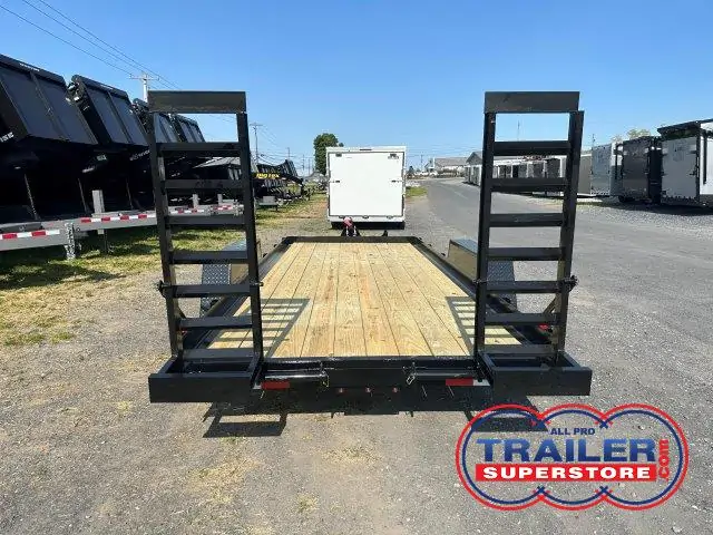 a trailer with a wooden deck is parked on the side of the road .